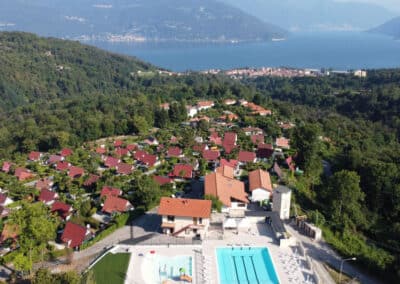 Luftaufnahme des Villaggio Olandese mit Blick vom Pool über Germignaga zum Lago Maggiore